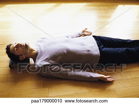 Man lying on floor View Large Photo Image Stock Image - Man lying on floor. Fotosearch
