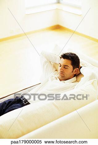 Man lying on sofa View Large Photo Image Stock Photography - Man lying on sofa. Fotosearch