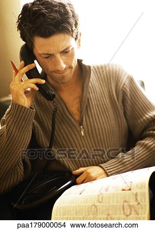 Man phoning with newspaper on knees View Large Photo Image Picture - Man phoning with newspaper on knees. Fotosearch