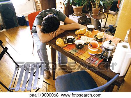 Man resting head on breakfast table View Large Photo Image Stock Photo - Man resting head on breakfast table. Fotosearch