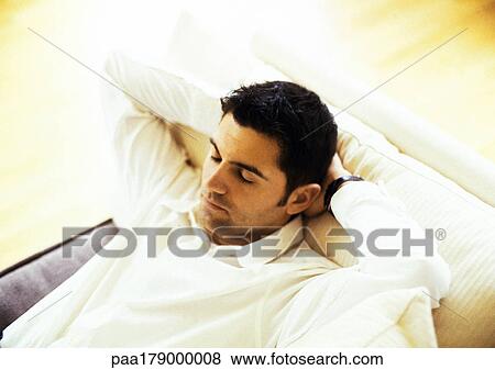 Man resting on sofa, close-up View Large Photo Image Stock Photo - Man resting on sofa, close-up. Fotosearch