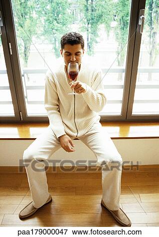 Man sitting in front of window, drinking wine View Large Photo Image Stock Photo - Man sitting in front of window, drinking wine. Fotosearch