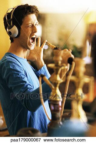 Man wearing headphones, holding hookah like a microphone View Large Photo Image Stock Photo - Man wearing headphones, holding hookah like a microphone. Fotosearch