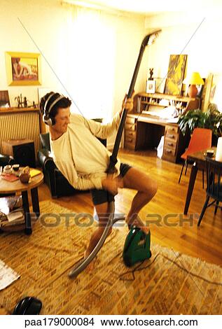 Man with headphones playing air guitar with vacuum View Large Photo Image Picture - Man with headphones playing air guitar with vacuum. Fotosearch