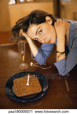 Woman alone at table with cake and one candle, portrait View Large Photo Image Stock Image - Woman alone at table with cake and one candle, portrait. Fotosearch