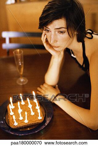 Woman alone at table with cake and candles View Large Photo Image Stock Image - Woman alone at table with cake and candles. Fotosearch