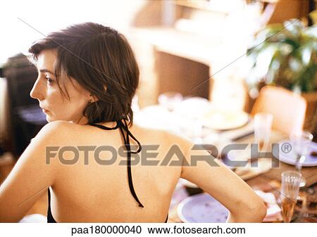 Woman at table, wearing halter top, rear view View Large Photo Image Stock Image - Woman at table, wearing halter top, rear view. Fotosearch