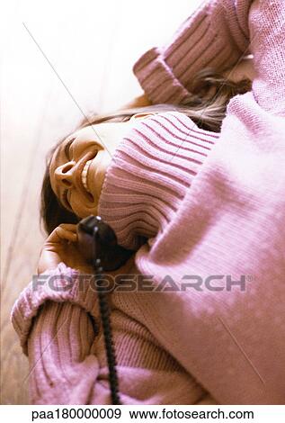 Woman lying on bed with phone in hand View Large Photo Image Stock Photo - Woman lying on bed with phone in hand. Fotosearch
