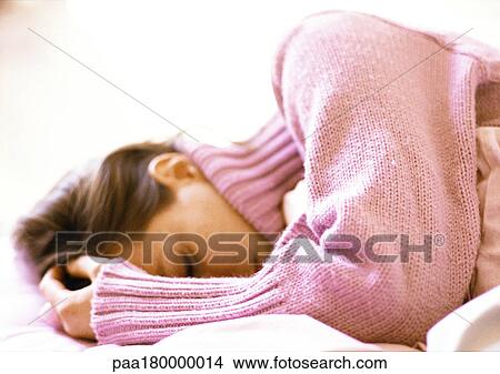 Woman lying with hand on head, close-up View Large Photo Image Picture - Woman lying with hand on head, close-up. Fotosearch