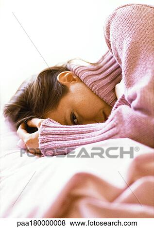 Woman lying with hand on head, close-up View Large Photo Image Stock Photo - Woman lying with hand on head, close-up. Fotosearch