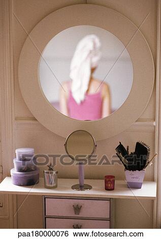 Stock Photograph - Woman reflected in mirror, rear view. Fotosearch