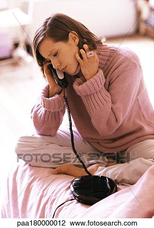 Woman sitting on bed, phoning View Large Photo Image Stock Image - Woman sitting on bed, phoning. Fotosearch