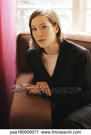 Woman sitting on sofa, portrait View Large Photo Image Stock Photo - Woman sitting on sofa, portrait. Fotosearch