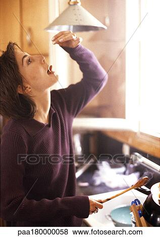 Woman tasting pasta noodle in kitchen View Large Photo Image Stock Photo - Woman tasting pasta noodle in kitchen. Fotosearch