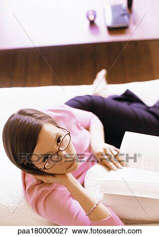 Woman with book, looking up at camera, portrait View Large Photo Image Stock Photo - Woman with book, looking up at camera, portrait. Fotosearch