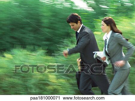 Businessman and woman running in park, blurred View Large Photo Image Stock Image - Businessman and woman running in park, blurred. Fotosearch