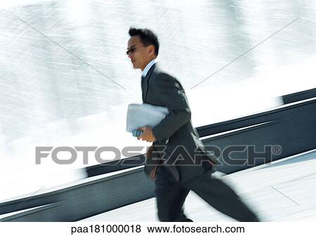 Businessman hurrying with cell phone in hand View Large Photo Image Stock Photo - Businessman hurrying with cell phone in hand. Fotosearch