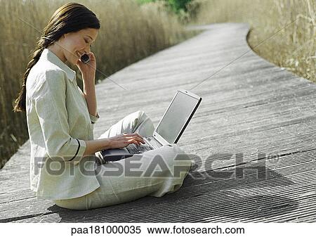 Businesswoman sitting with laptop computer, outdoors View Large Photo Image Stock Photography - Businesswoman sitting with laptop computer, outdoors. Fotosearch