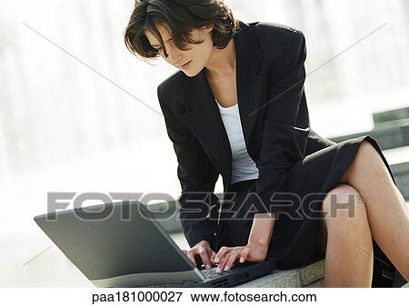 Businesswoman using laptop computer outdoors, close-up View Large Photo Image Stock Photo - Businesswoman using laptop computer outdoors, close-up. Fotosearch