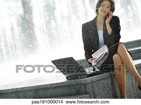 Businesswoman with cell phone and laptop computer, outdoors View Large Photo Image Picture - Businesswoman with cell phone and laptop computer, outdoors. Fotosearch