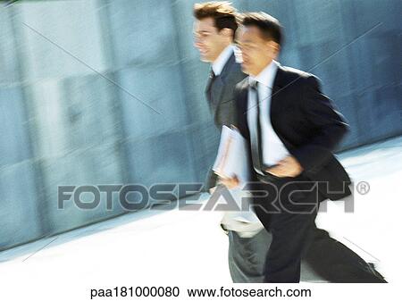 Two businessmen walking outdoors, blurred motion View Large Photo Image Stock Image - Two businessmen walking outdoors, blurred motion. Fotosearch