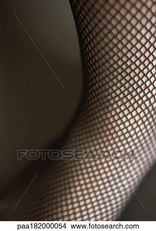 Leg wearing fishnet stocking, close-up View Large Photo Image Picture - Leg wearing fishnet stocking, close-up. Fotosearch