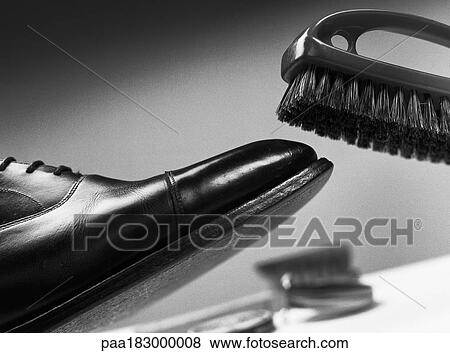 Brush above leather shoe, close-up, b&w View Large Photo Image Stock Photo - Brush above leather shoe, close-up, b&w. Fotosearch