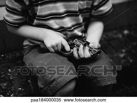 Stock Photography - Child holding gun, mid-section, b&w. Fotosearch