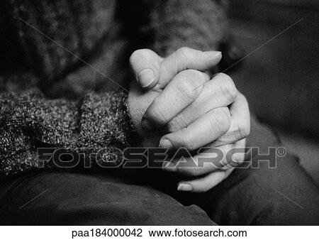 Stock Image - Clasped hands, close-up, b&w. Fotosearch