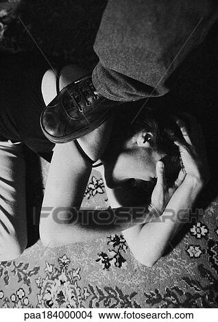 Picture - Foot on woman curled up on ground, close-up, b&w. Fotosearch