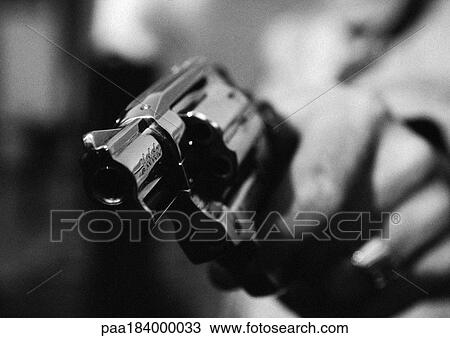 Stock Image - Hand holding gun, close-up, b&w. Fotosearch