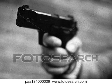 Stock Photo - Hand holding gun, close-up, b&w. Fotosearch
