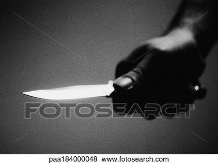 Stock Photo - Hand holding knife, close-up, b&w. Fotosearch