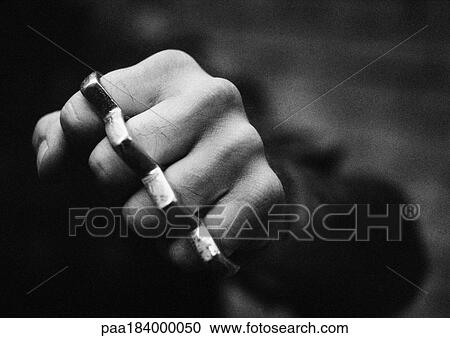 Stock Image - Hand with brass knuckles, close-up, b&w. Fotosearch