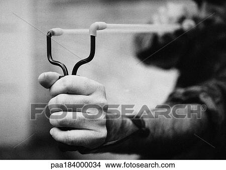 Picture - Hands holding sling shot, close-up, b&w. Fotosearch