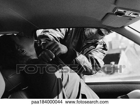 Picture - Man holding gun to woman's neck through car window, b&w. Fotosearch