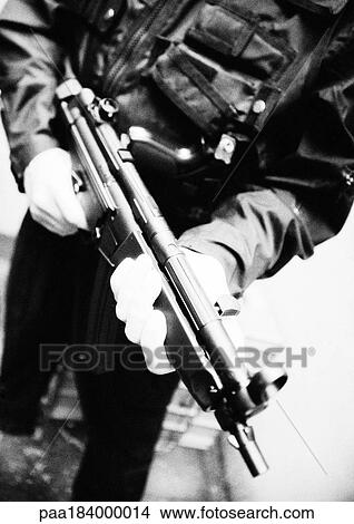 Man holding sub-machine gun, close-up, b&w View Large Photo Image Picture - Man holding sub-machine gun, close-up, b&w. Fotosearch