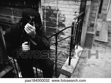 Masked man holding sub-machine gun, b&w View Large Photo Image Stock Image - Masked man holding sub-machine gun, b&w. Fotosearch