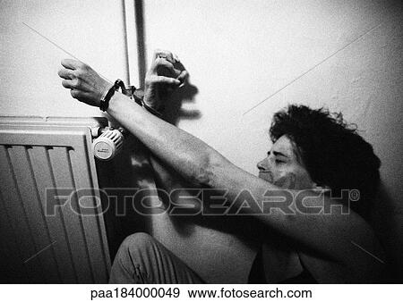 Woman handcuffed to radiator, b&w View Large Photo Image Stock Photo - Woman handcuffed to radiator, b&w. Fotosearch