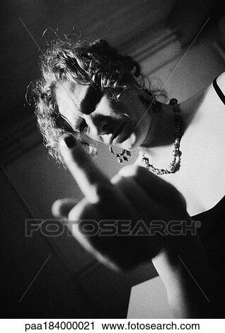 Stock Image - Woman making obscene gesture, close-up, blurred, b&w. Fotosearch