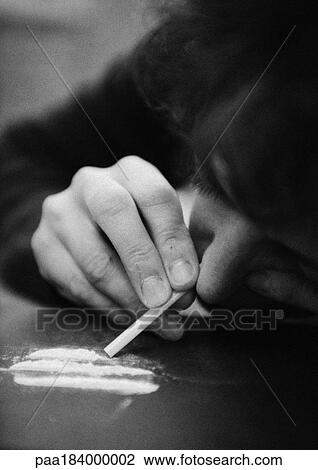 Stock Image - Woman taking drugs, close-up, b&w. Fotosearch