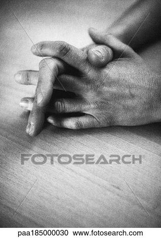 Stock Image - Clasped hands, close-up, b&w. Fotosearch