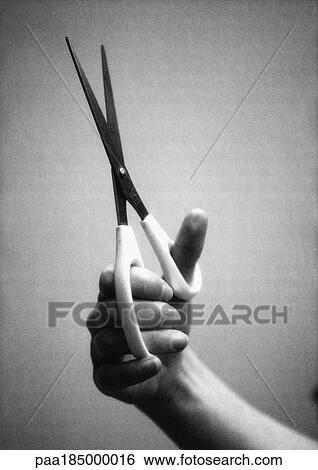 Stock Photograph - Hand holding scissors, close-up, b&w. Fotosearch