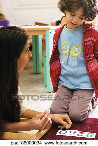 Child kneeling, woman lying on floor, close-up View Large Photo Image Picture - Child kneeling, woman lying on floor, close-up. Fotosearch
