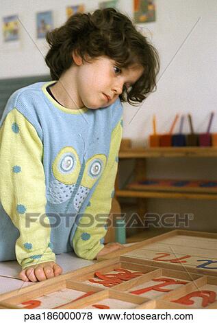 Child looking at plastic letters View Large Photo Image Stock Photo - Child looking at plastic letters. Fotosearch