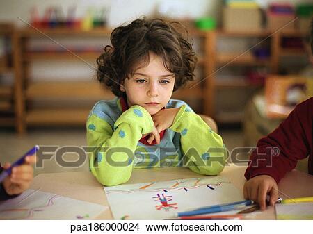 Child sitting at table, head and shoulders View Large Photo Image Picture - Child sitting at table, head and shoulders. Fotosearch