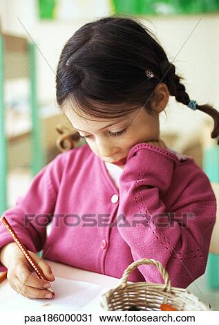 Stock Image - Child writing, head and shoulders, close-up. Fotosearch