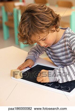 Child writing with chalk on slate View Large Photo Image Stock Image - Child writing with chalk on slate. Fotosearch