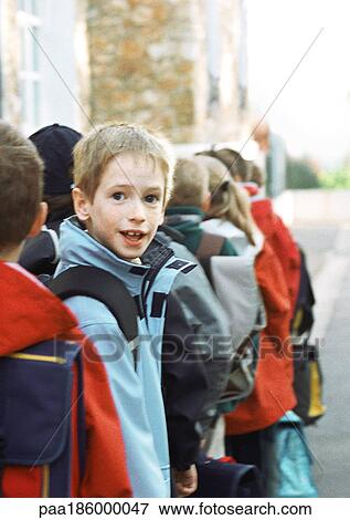 Children in single file, one looking back, portrait View Large Photo Image Stock Photo - Children in single file, one looking back, portrait. Fotosearch