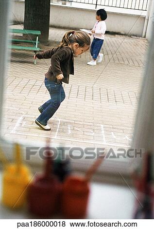 Children outdoors, one playing hopscotch, side view View Large Photo Image Stock Photo - Children outdoors, one playing hopscotch, side view. Fotosearch